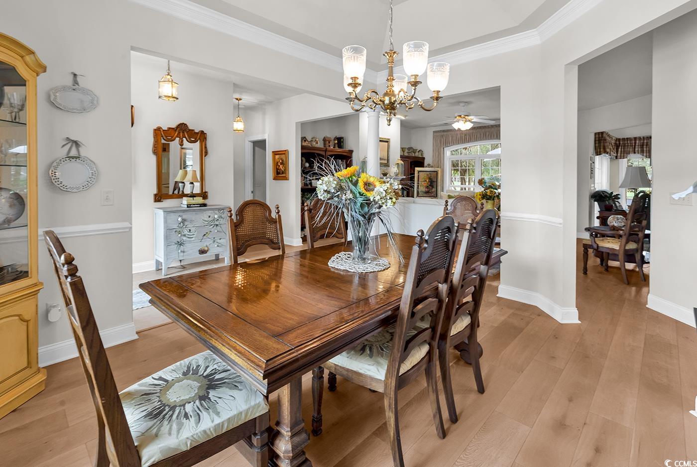 4507 Smilax Place Murrells Inlet, SC 29576 - Photo 4 of 39 Dining space with a chandelier, light wood finished floors, ornamental molding, and ceiling fan