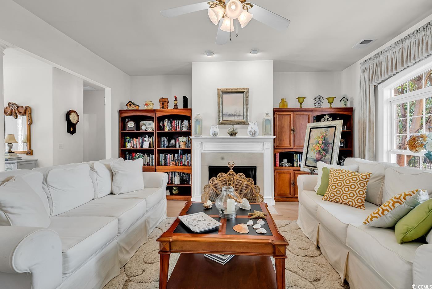 4507 Smilax Place Murrells Inlet, SC 29576 - Photo 10 of 39 Living room featuring a ceiling fan, a fireplace, and light wood-type flooring