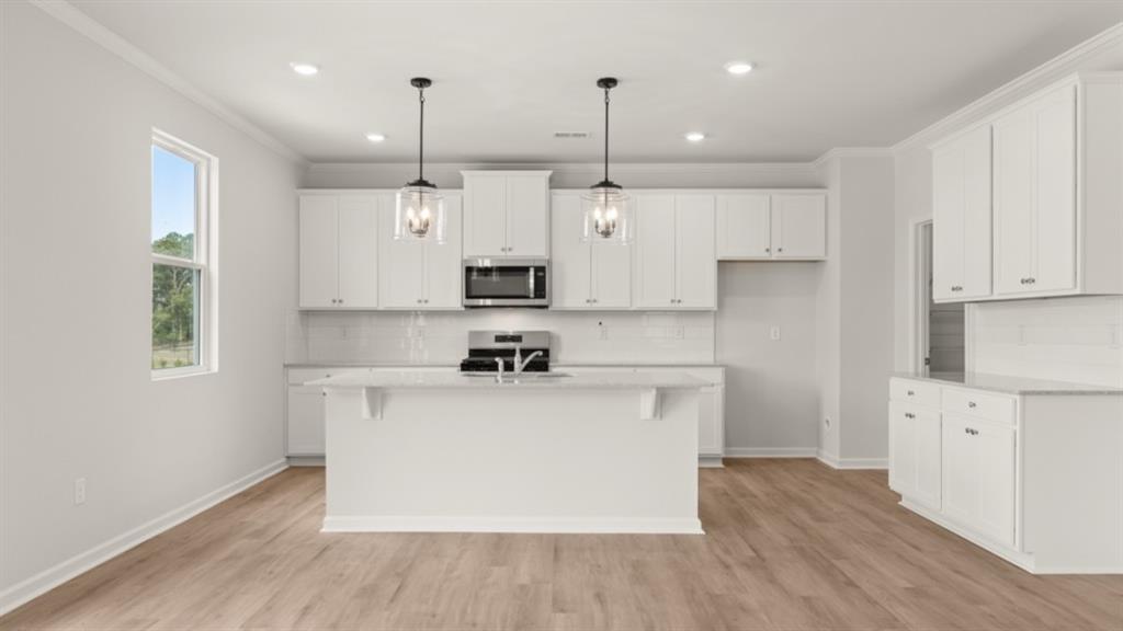 904 Sundown Point Villa Rica, GA 30180 - Photo 13 of 83 a kitchen with kitchen island white cabinets stainless steel appliances and wooden floor