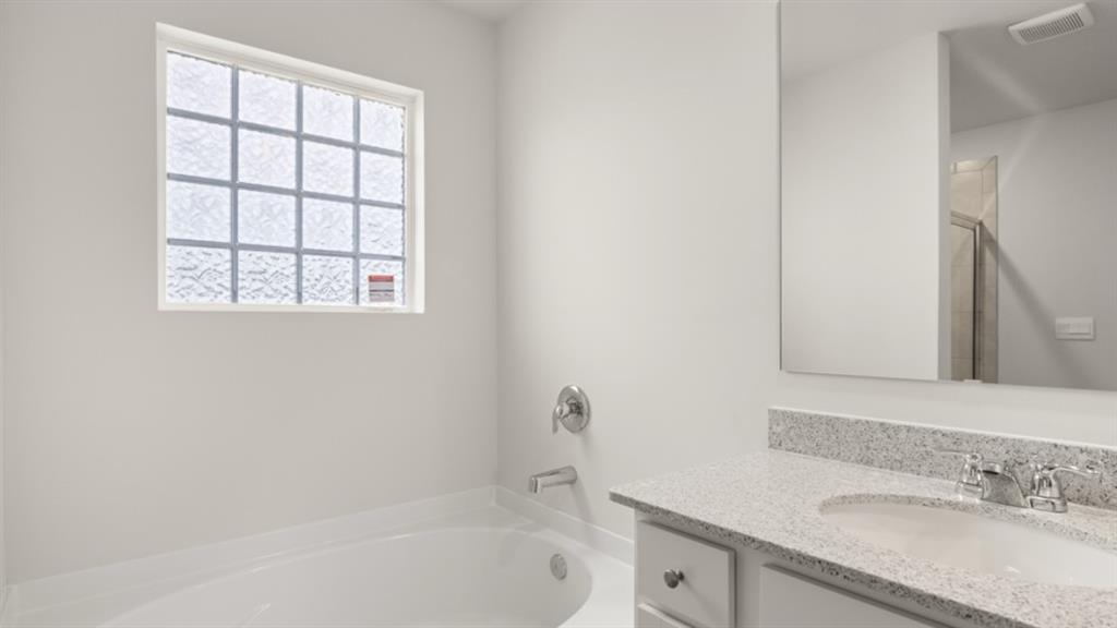 904 Sundown Point Villa Rica, GA 30180 - Photo 35 of 83 a bathroom with a granite countertop sink a mirror and a bathtub