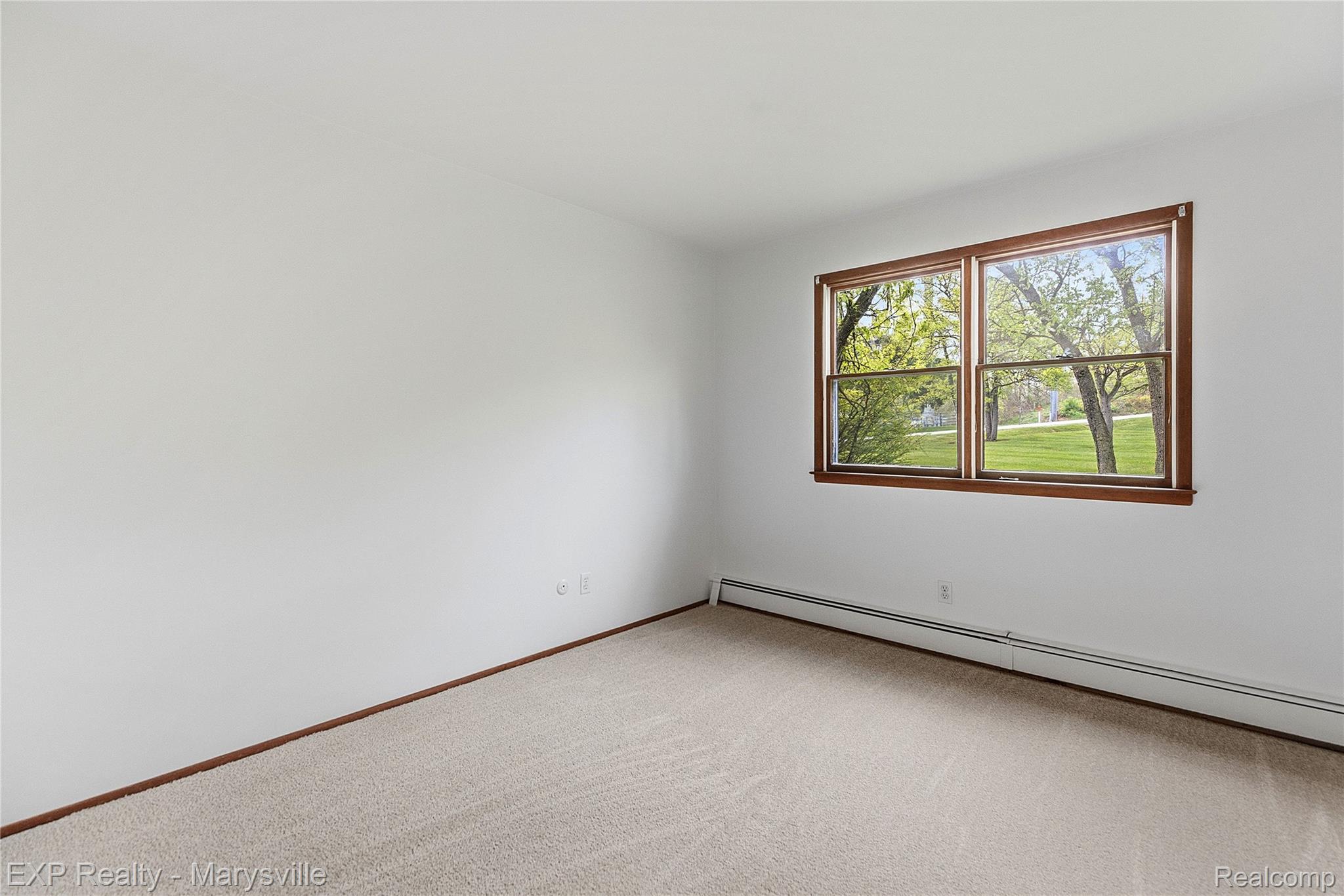 3345 Beach Road Port Huron, MI 48060 - Photo 22 of 89 Empty room featuring a baseboard heating unit and light colored carpet