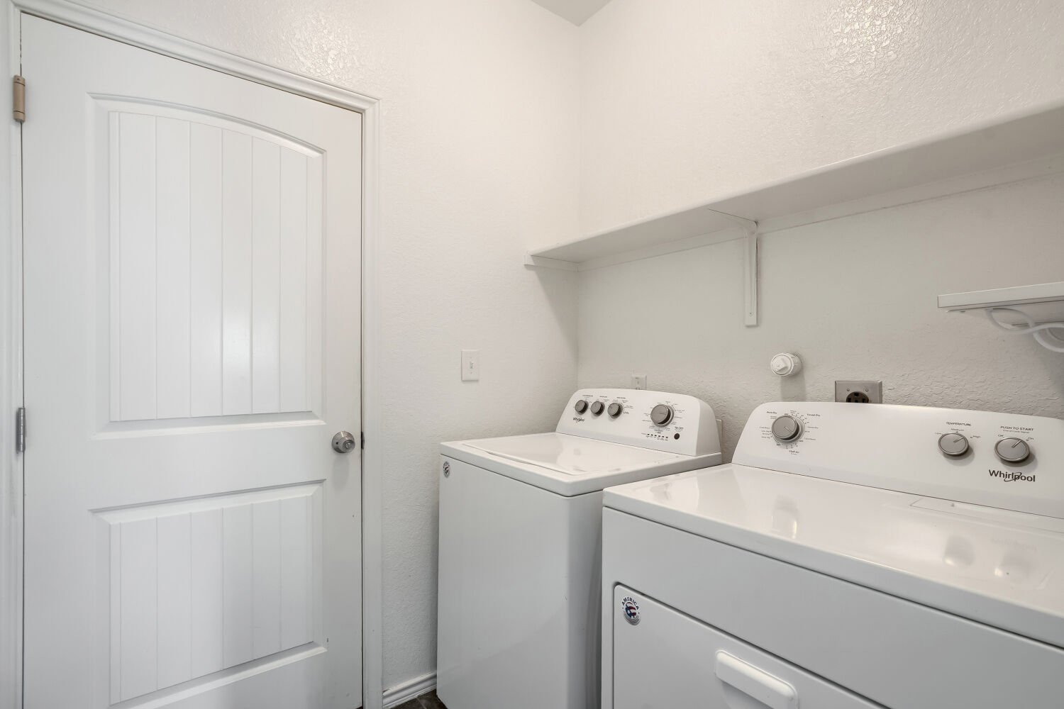 2420 Ranger Pass Seguin, TX 78155 - Photo 24 of 28 Utility area featuring a paneled door, overhead shelving, and white walls