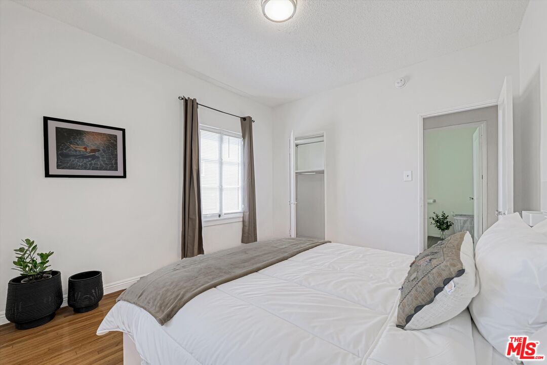 153 West Channel Road Santa Monica, CA 90402 - Photo 5 of 74 a bedroom with a bed and wooden floor