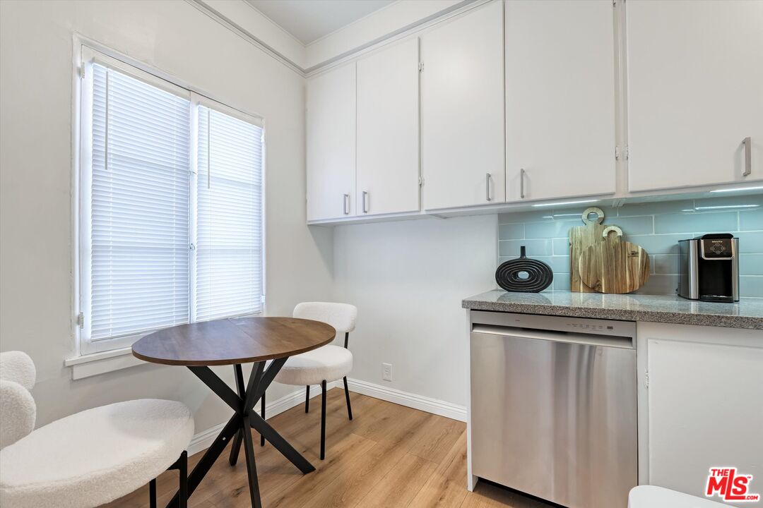 153 West Channel Road Santa Monica, CA 90402 - Photo 7 of 74 a kitchen with stainless steel appliances granite countertop a table chairs sink and cabinets