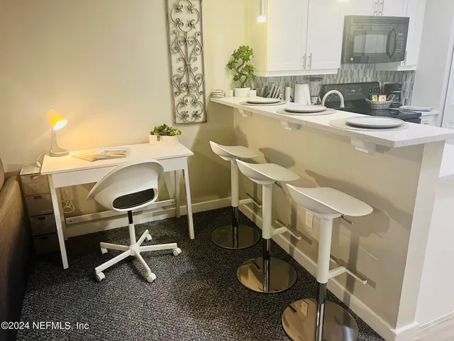 a kitchen with a table chairs sink and cabinets