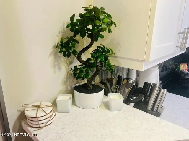 a white vase with flowers sitting on a table