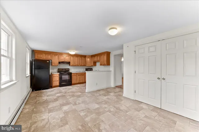 a view of kitchen with refrigerator cabinets and window
