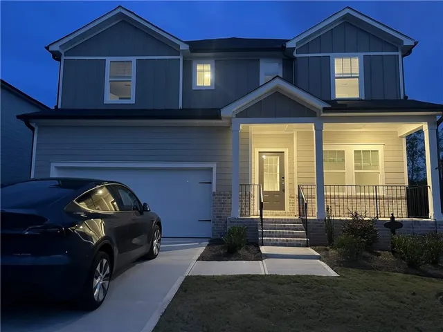 a view of a house with a small yard and furniture