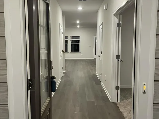 a view of a hallway with wooden floor and staircase