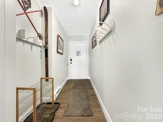 a view of a hallway with wooden floor and staircase