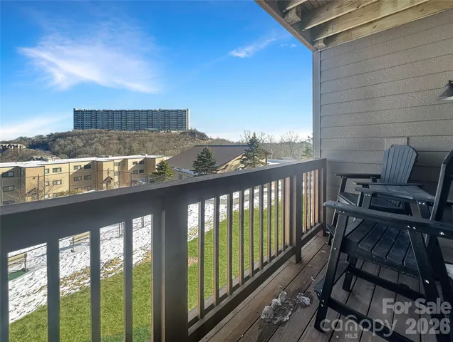 a view of a balcony with a chair and wooden floor