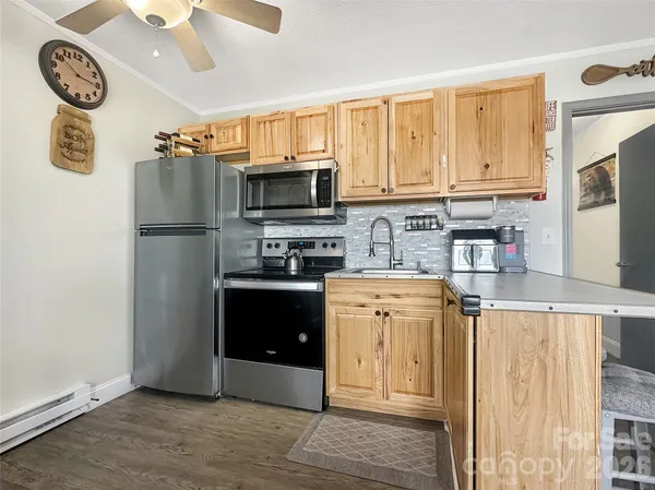 a kitchen with a refrigerator a stove a microwave a sink and dishwasher with wooden floor