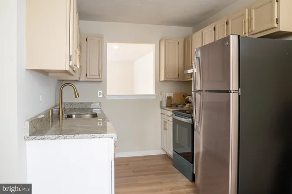a kitchen with granite countertop stainless steel appliances a refrigerator sink and cabinets