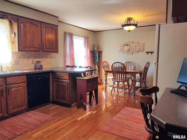 a view of a a dining room with furniture window and wooden floor