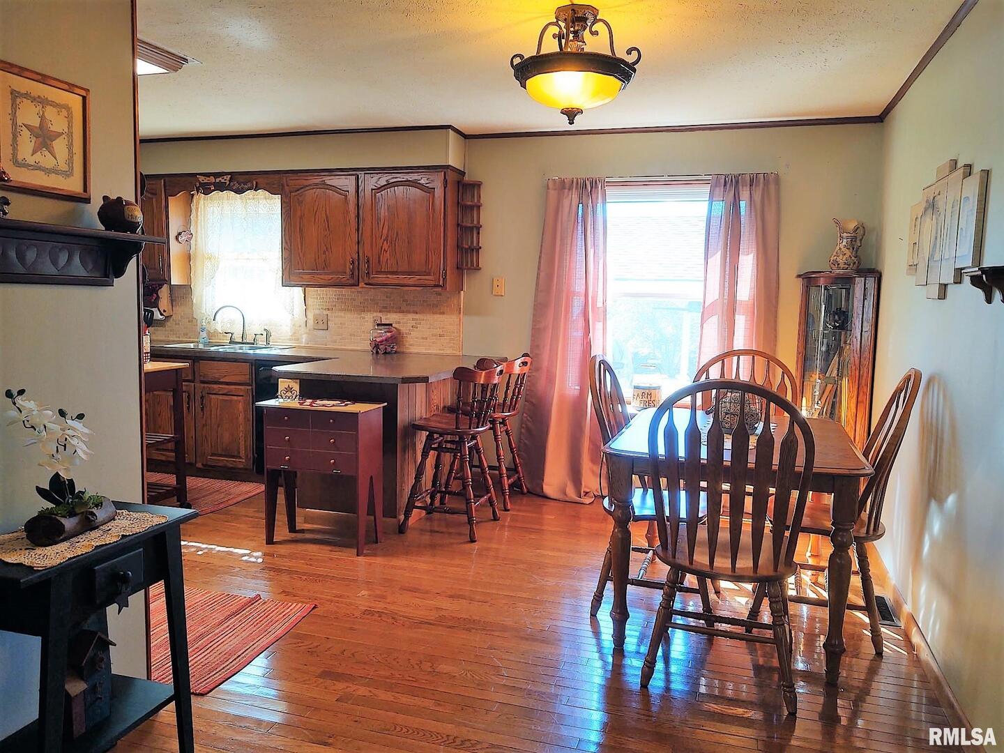 901 Locust Street Vienna, IL 62995 - Photo 15 of 25 a view of a a dining room with furniture window and wooden floor