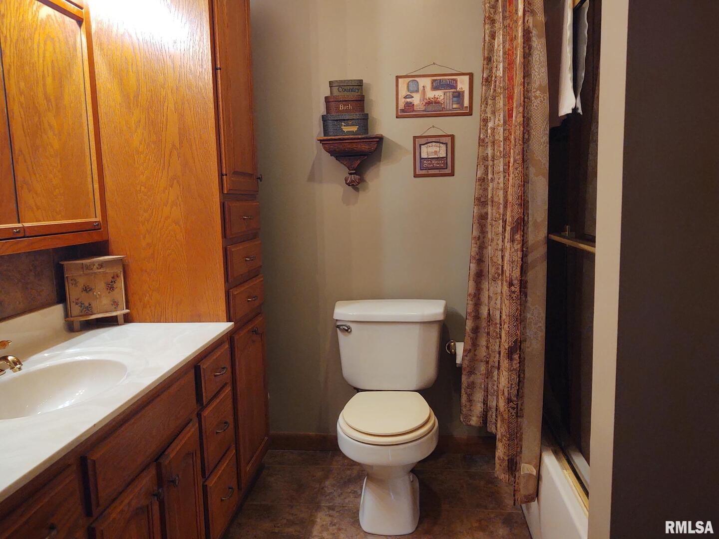 901 Locust Street Vienna, IL 62995 - Photo 24 of 25 a bathroom with a granite countertop toilet and a sink