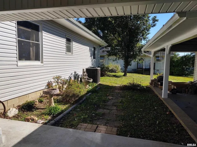 a view of a house with sitting area and covered with trees