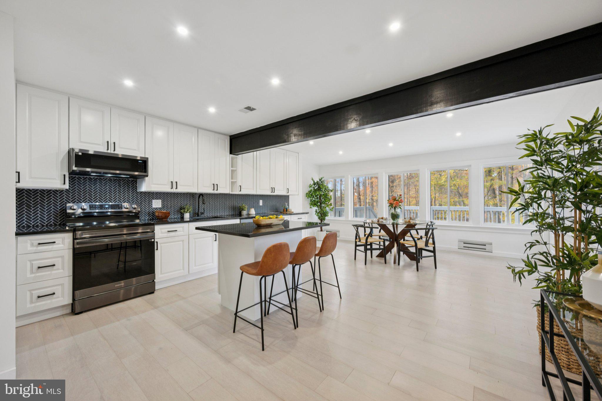 14912 Coles Chance Road North Potomac, MD 20878 - Photo 6 of 36 a kitchen with stainless steel appliances kitchen island granite countertop a stove a sink a refrigerator and a dining table