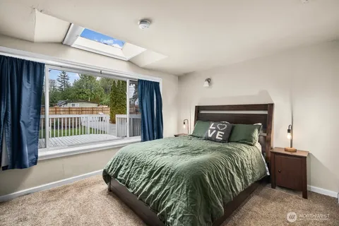 a bedroom with a bed and a large window