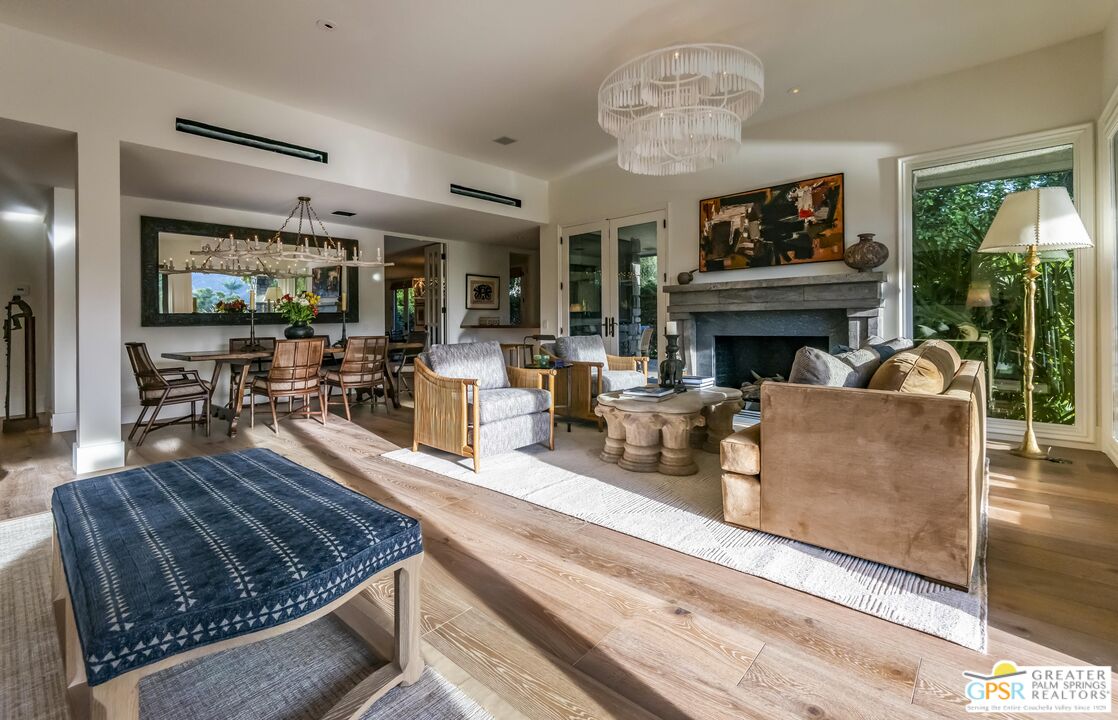 8 Surrey Court Rancho Mirage, CA 92270 - Photo 11 of 48 a living room with furniture a fireplace and a floor to ceiling window
