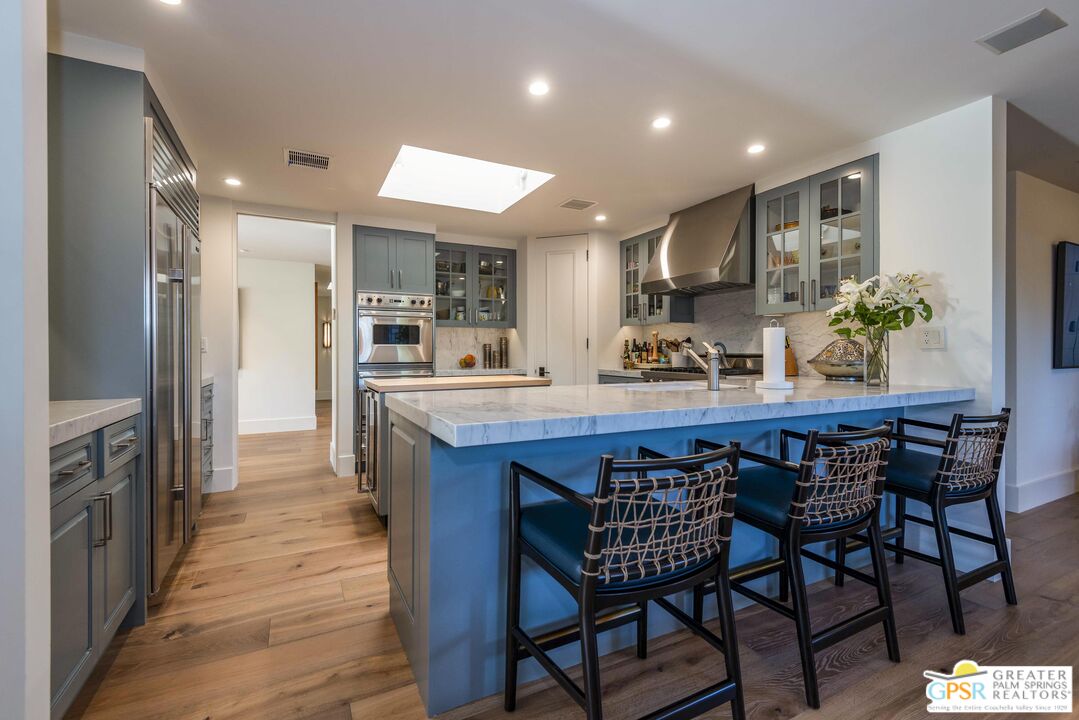 8 Surrey Court Rancho Mirage, CA 92270 - Photo 15 of 48 a kitchen with stainless steel appliances a dining table chairs and wooden floor