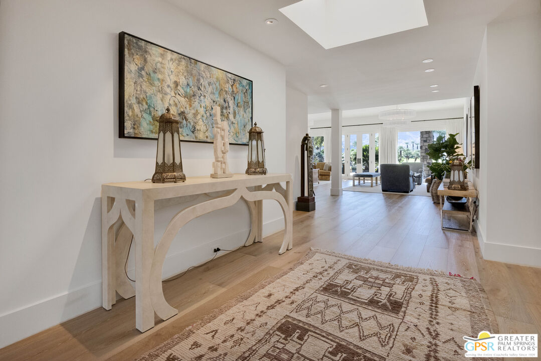 8 Surrey Court Rancho Mirage, CA 92270 - Photo 8 of 48 a living room with furniture a large window and wooden floor