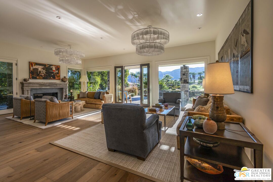 8 Surrey Court Rancho Mirage, CA 92270 - Photo 10 of 48 a living room with furniture a chandelier a fireplace and a flat screen tv