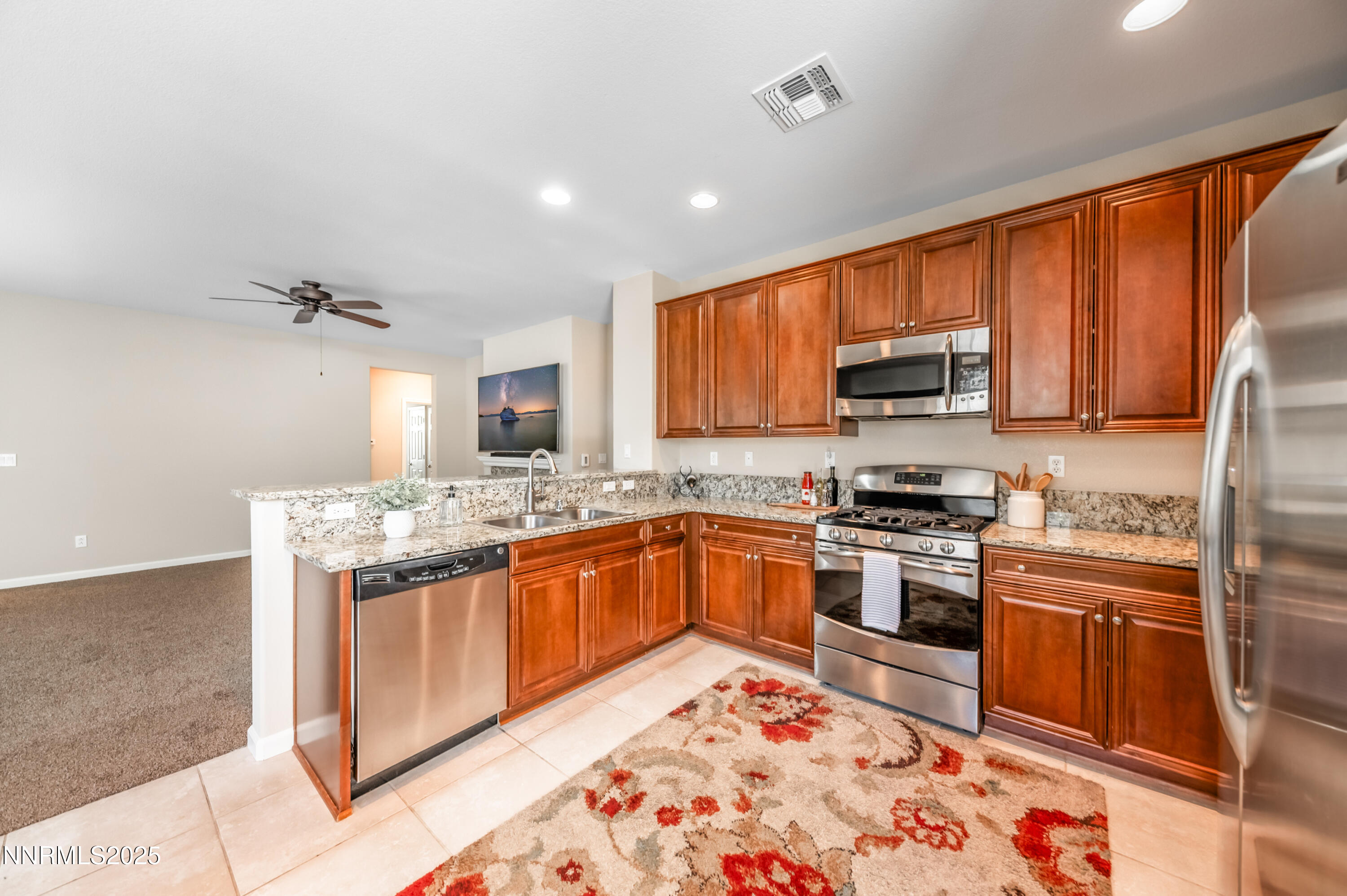10742 Amber Falls Drive Reno, NV 89521 - Photo 11 of 28 a kitchen with stainless steel appliances granite countertop a stove top oven a sink and dishwasher