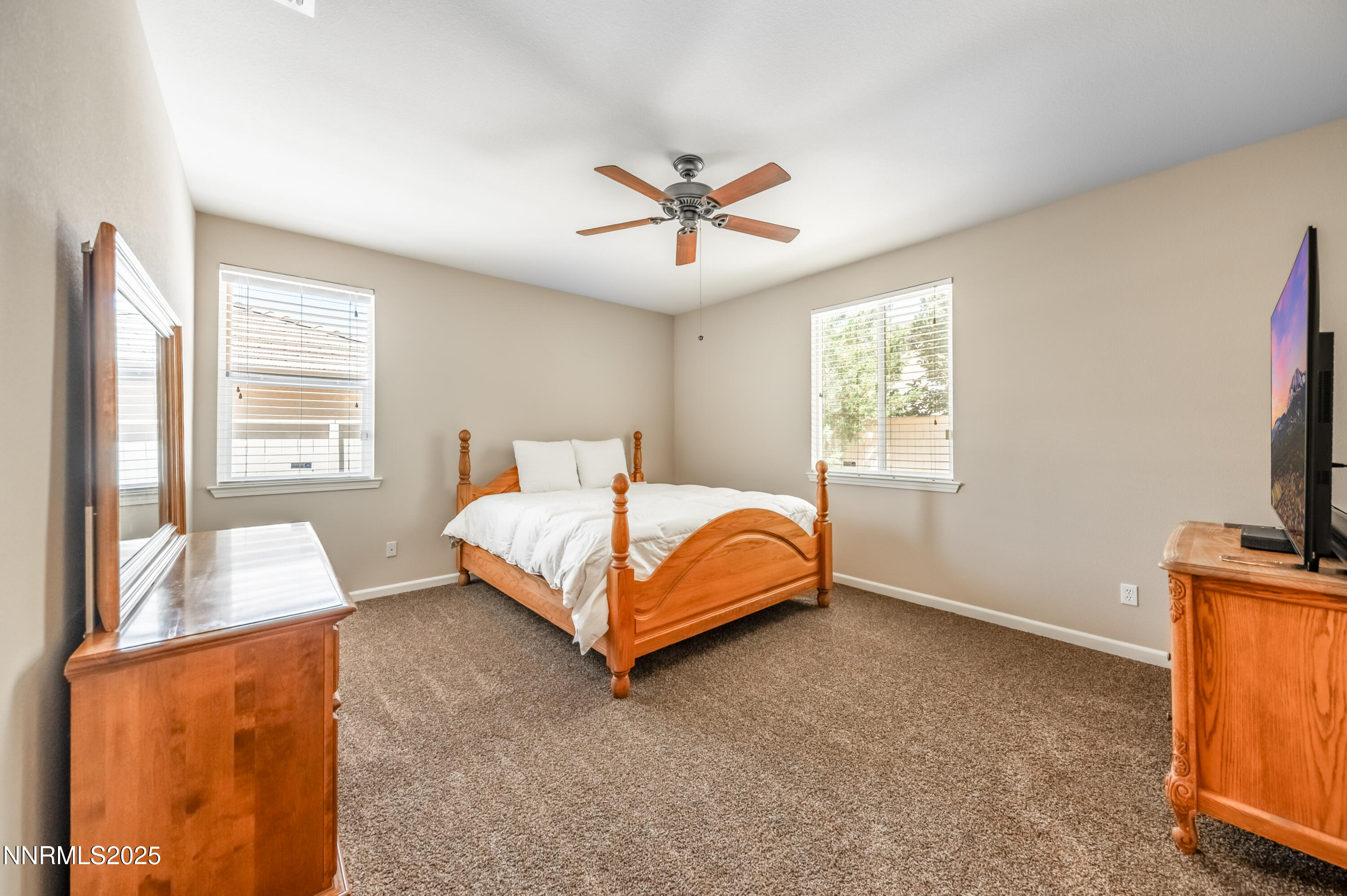 10742 Amber Falls Drive Reno, NV 89521 - Photo 12 of 28 a bedroom with a bed and a flat tv screen on dresser
