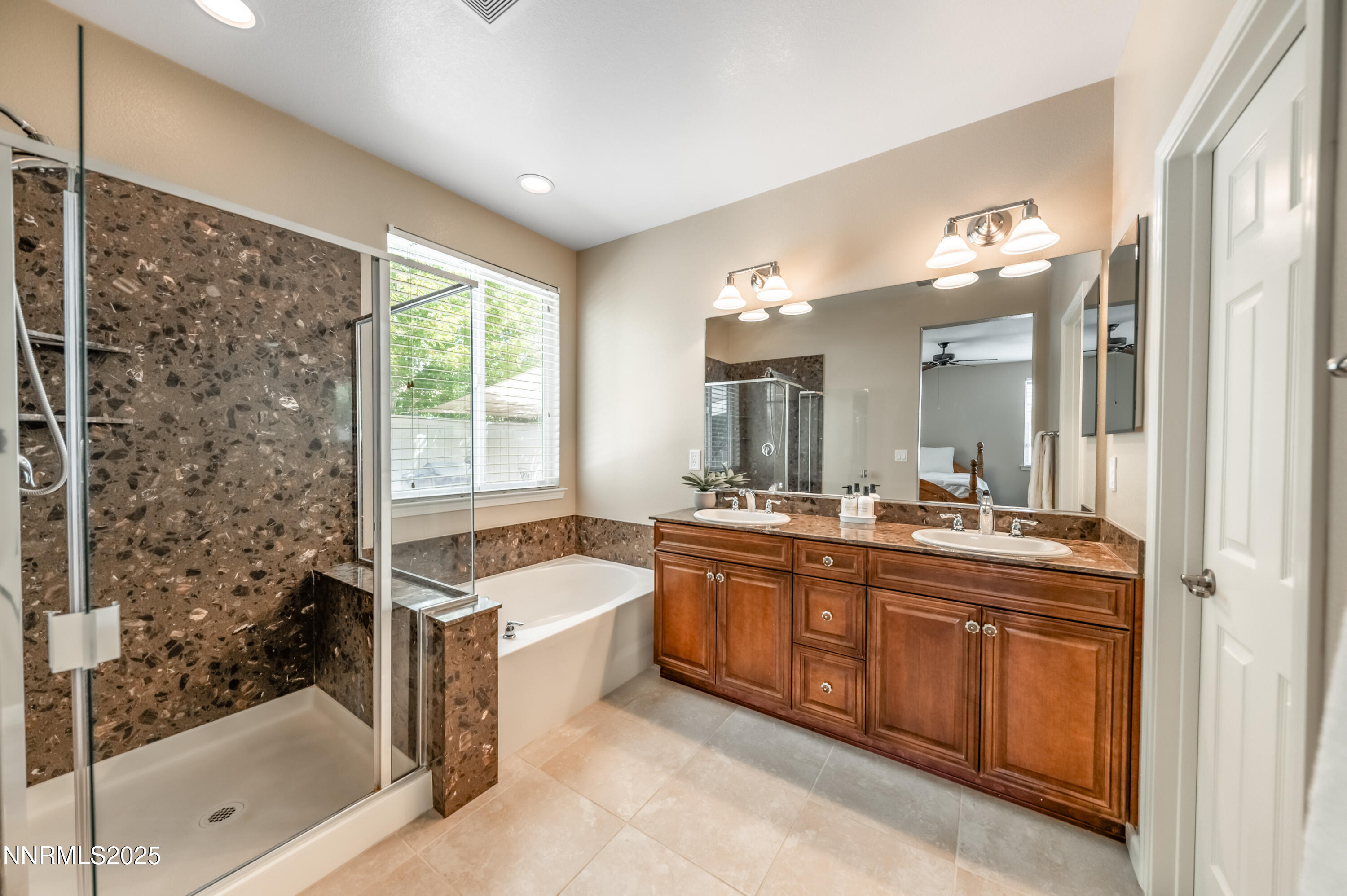 10742 Amber Falls Drive Reno, NV 89521 - Photo 14 of 28 a large bathroom with a tub sink shower and mirror