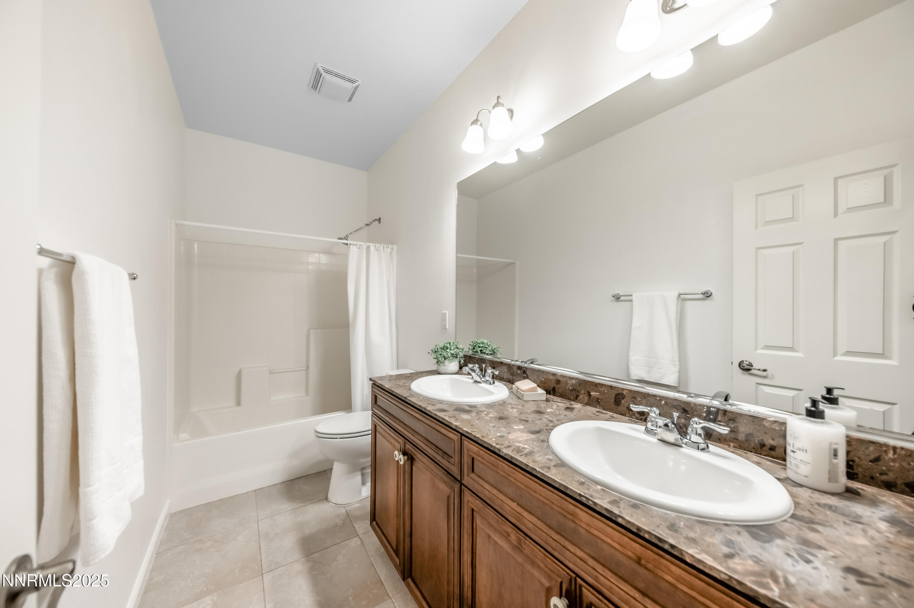 10742 Amber Falls Drive Reno, NV 89521 - Photo 23 of 28 a bathroom with a granite countertop double vanity sink a mirror and a bathtub