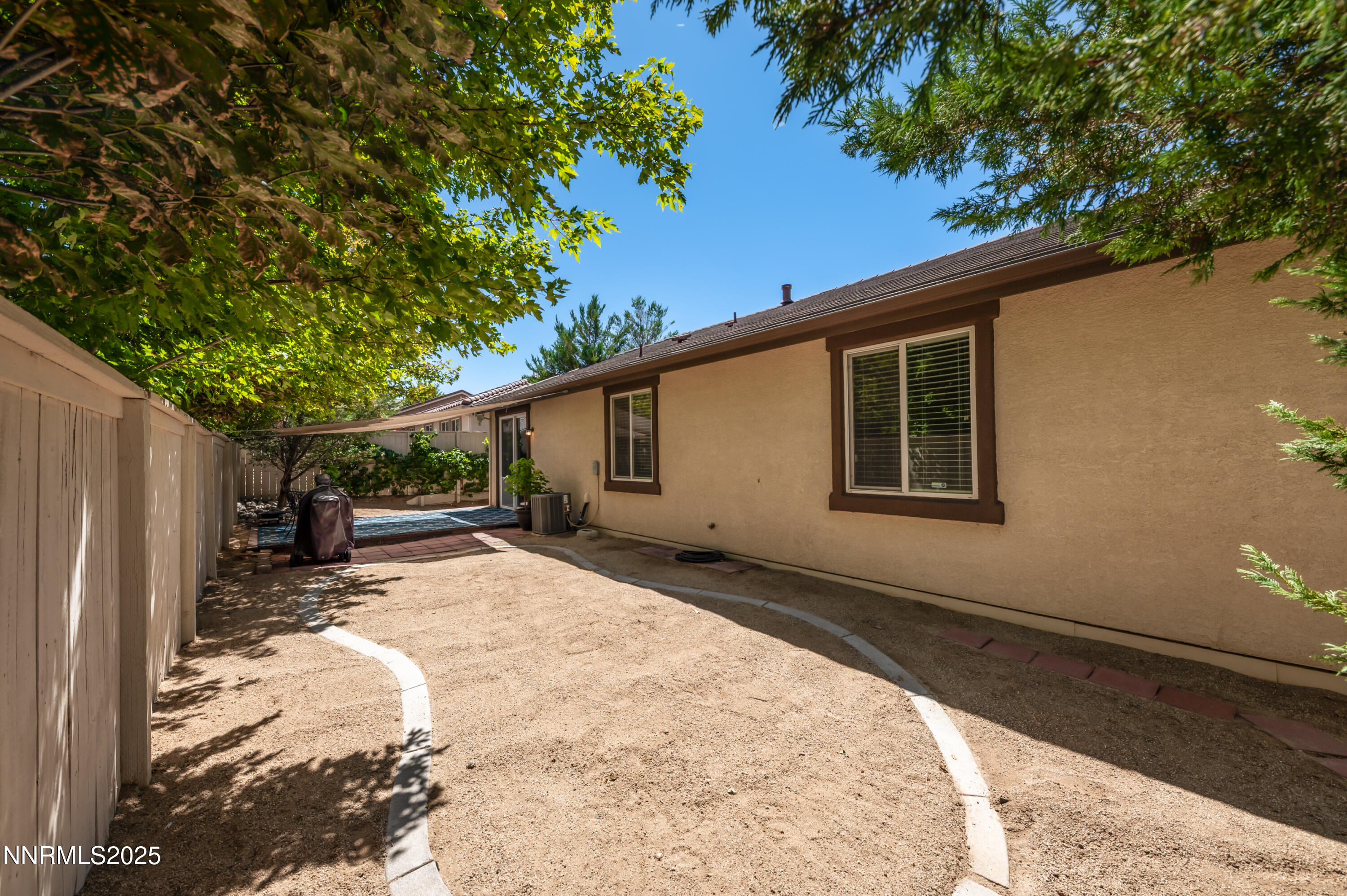 10742 Amber Falls Drive Reno, NV 89521 - Photo 27 of 28 a backyard of a house with wooden fence and large trees
