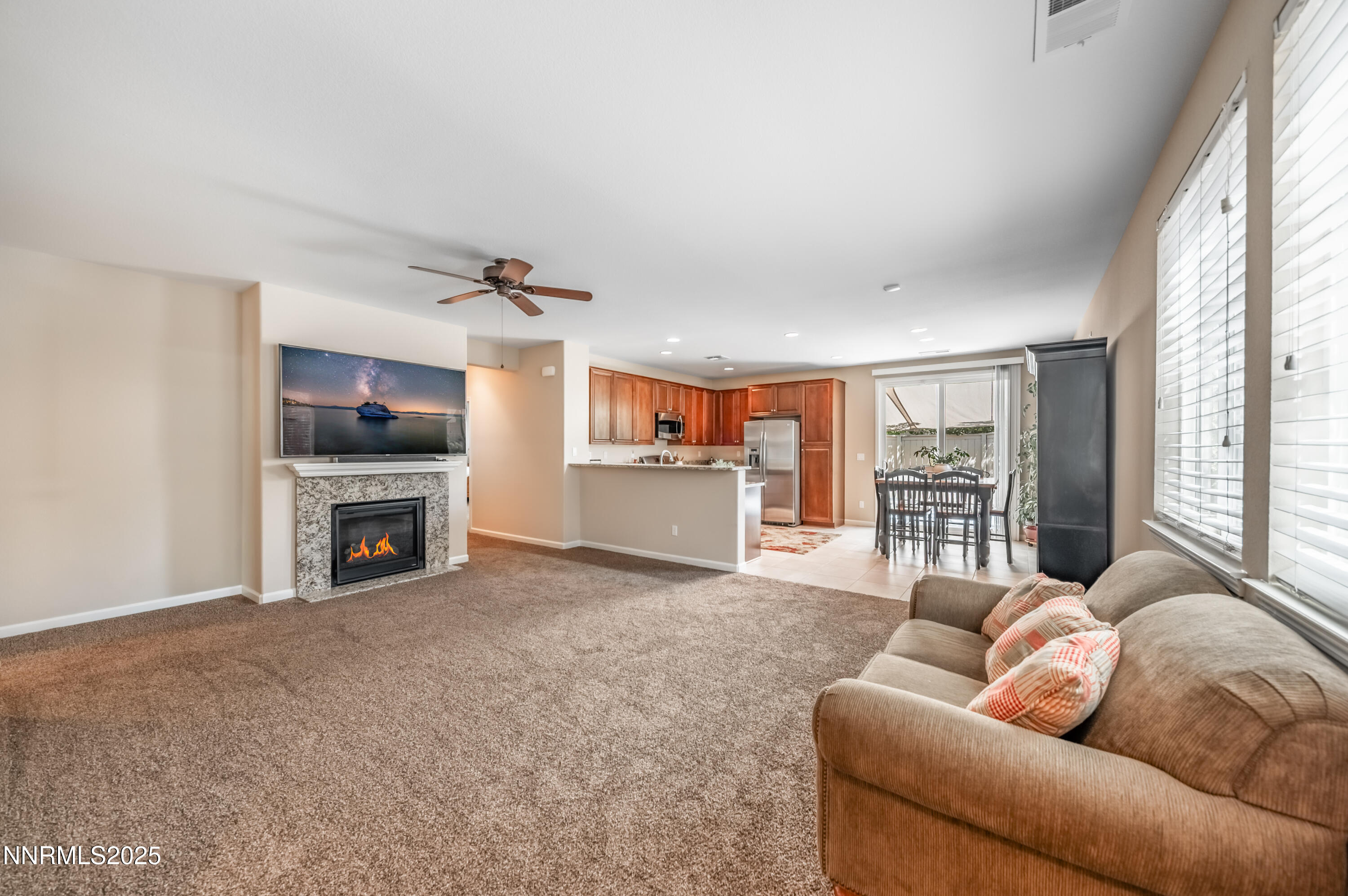 10742 Amber Falls Drive Reno, NV 89521 - Photo 6 of 28 a living room with furniture a fireplace and a flat screen tv