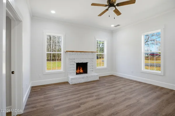 a view of an empty room with a window and fireplace