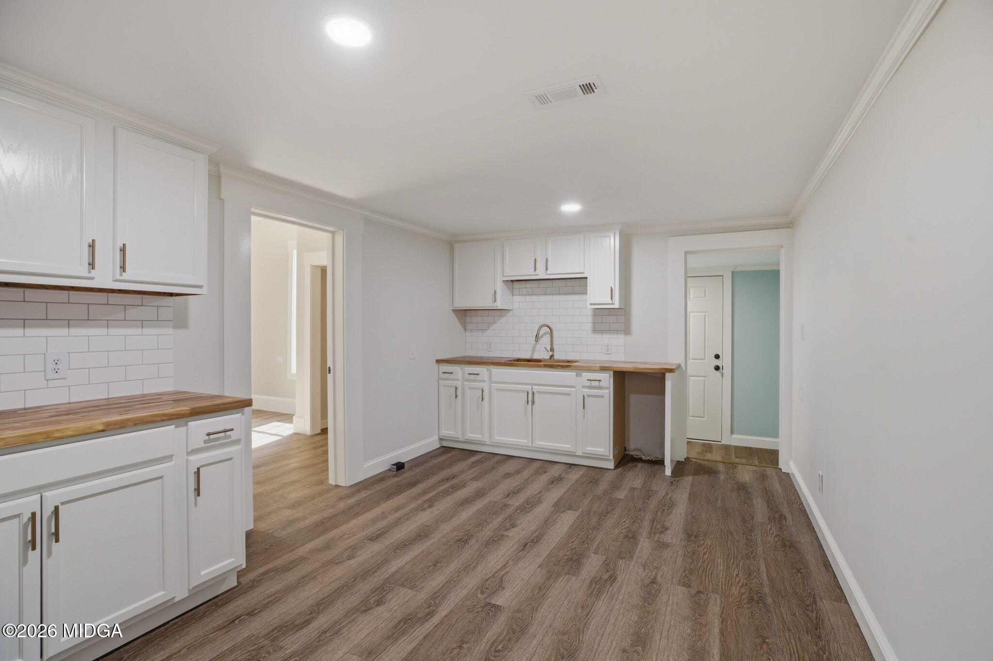 3181 Dames Ferry Road Forsyth, GA 31029 - Photo 16 of 36 a kitchen with white cabinets and wooden floor