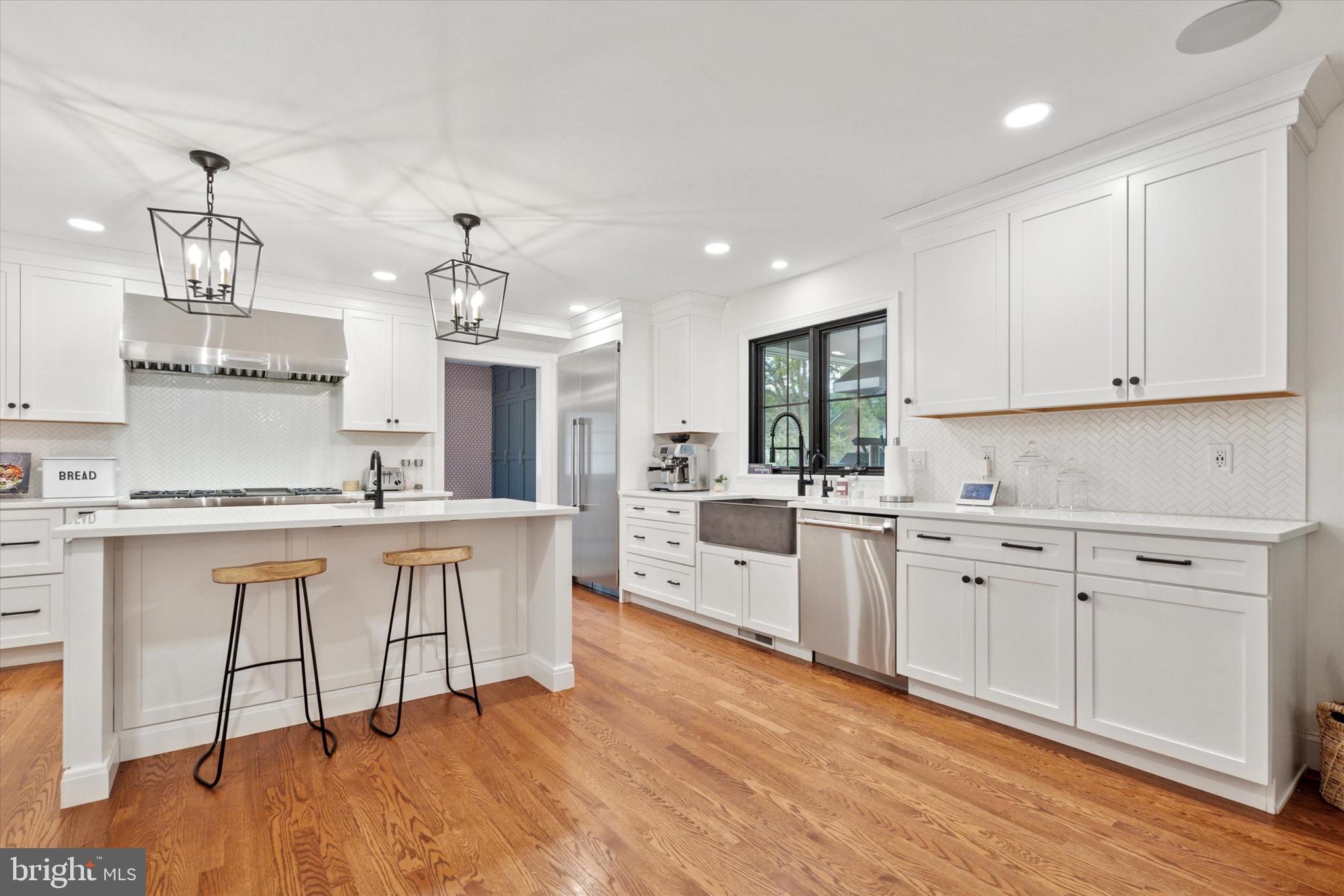 610 Dorset Road Devon, PA 19333 - Photo 26 of 54 a large white kitchen with granite countertop a stove a sink a window and white cabinets