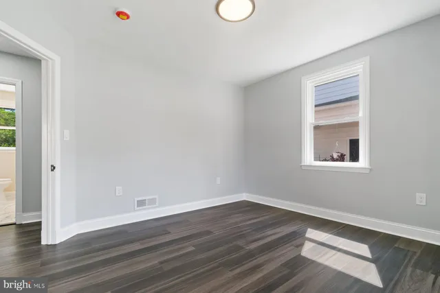 a view of a room that has wooden floor and window