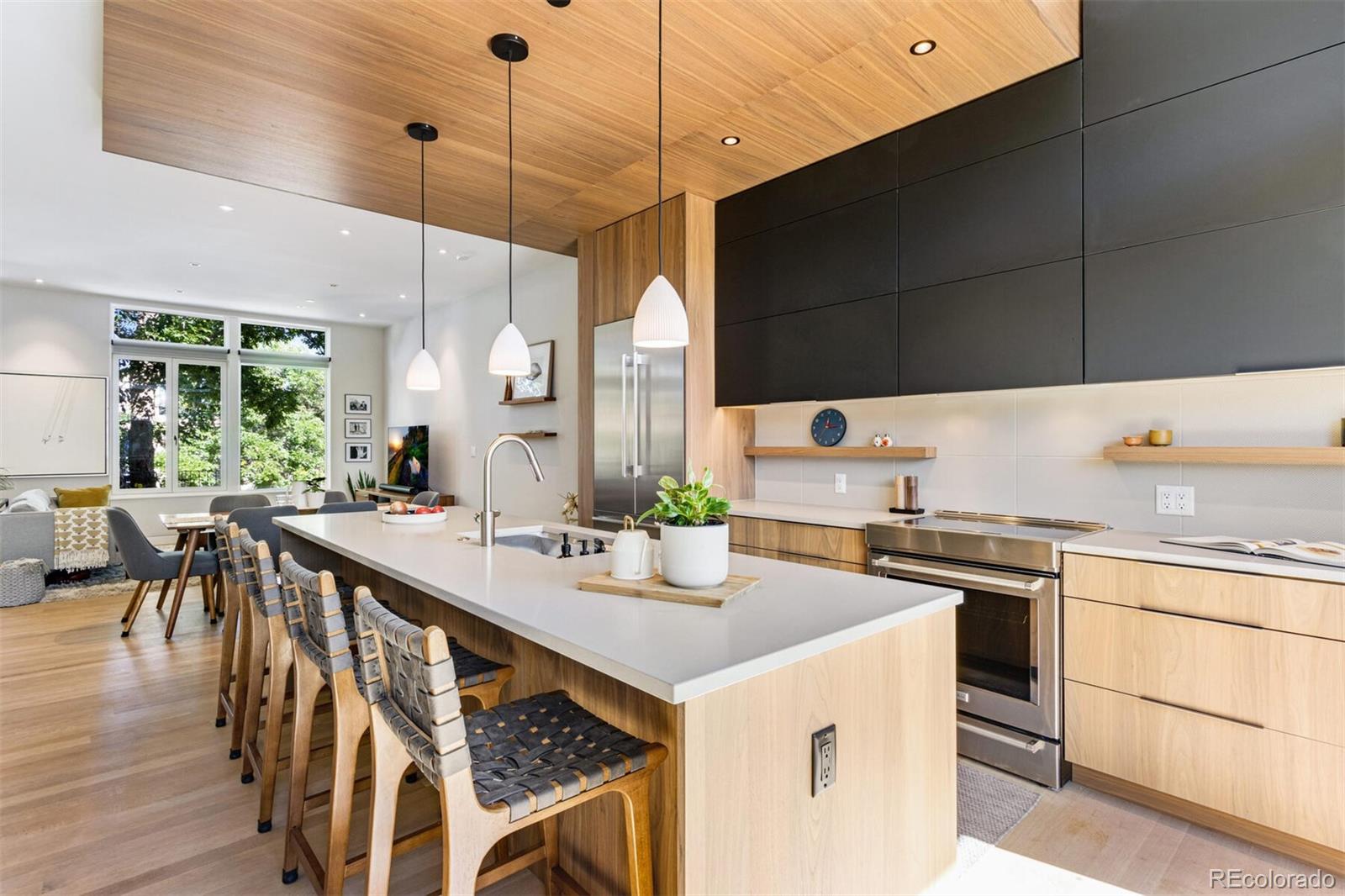 a kitchen with a stove a sink a kitchen island with chairs and wooden floor
