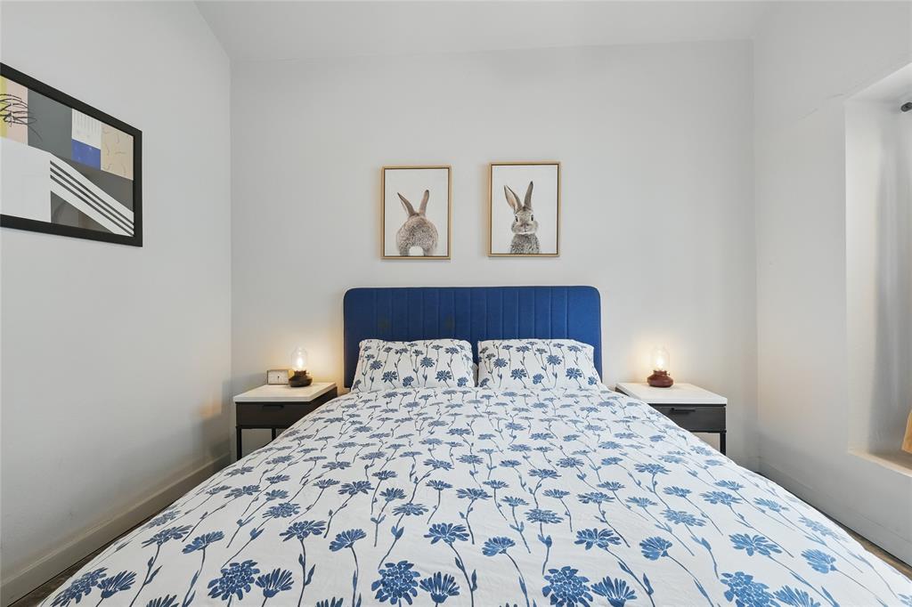 5963 Ross Avenue, Unit 202 Dallas, TX 75206 - Photo 11 of 15 a bedroom with a large bed and a lamp