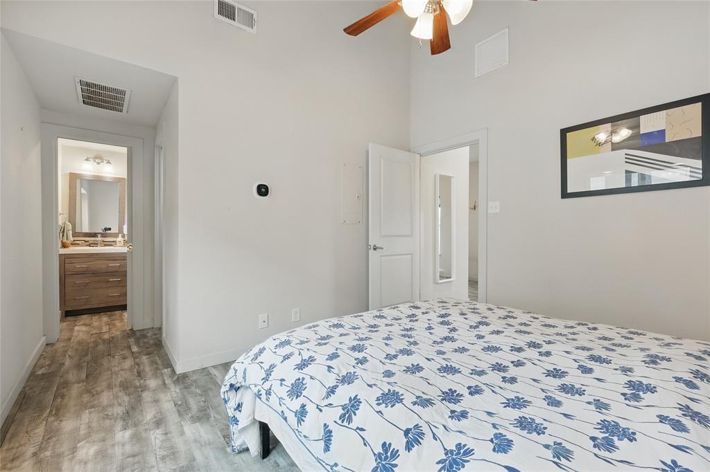 5963 Ross Avenue, Unit 202 Dallas, TX 75206 - Photo 13 of 15 a bedroom with a bed and a chandelier