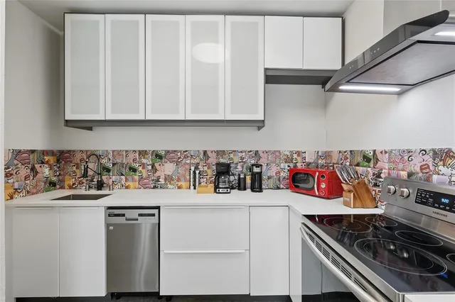 a kitchen with stainless steel appliances granite countertop a sink and cabinets