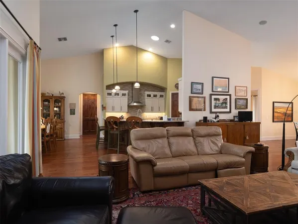 a living room with furniture kitchen view and a chandelier