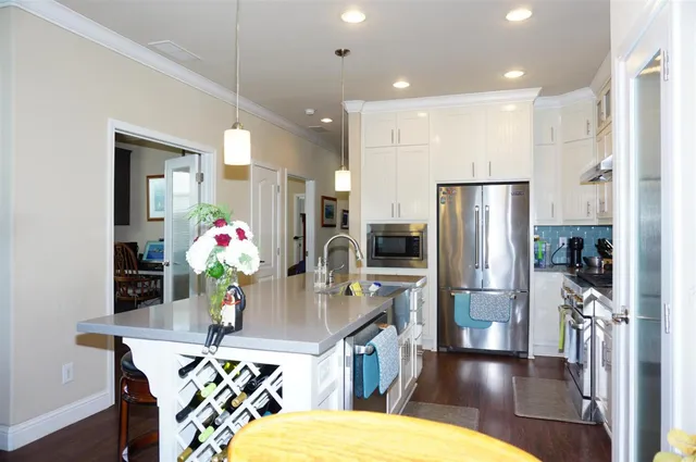 a kitchen with stainless steel appliances kitchen island granite countertop a dining table and chairs