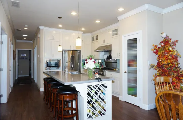 a kitchen with stainless steel appliances granite countertop a refrigerator and a stove top oven