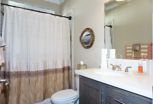 a bathroom with a sink vanity mirror and toilet