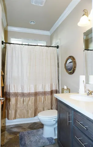 a bathroom with a granite countertop bathtub sink vanity mirror and toilet