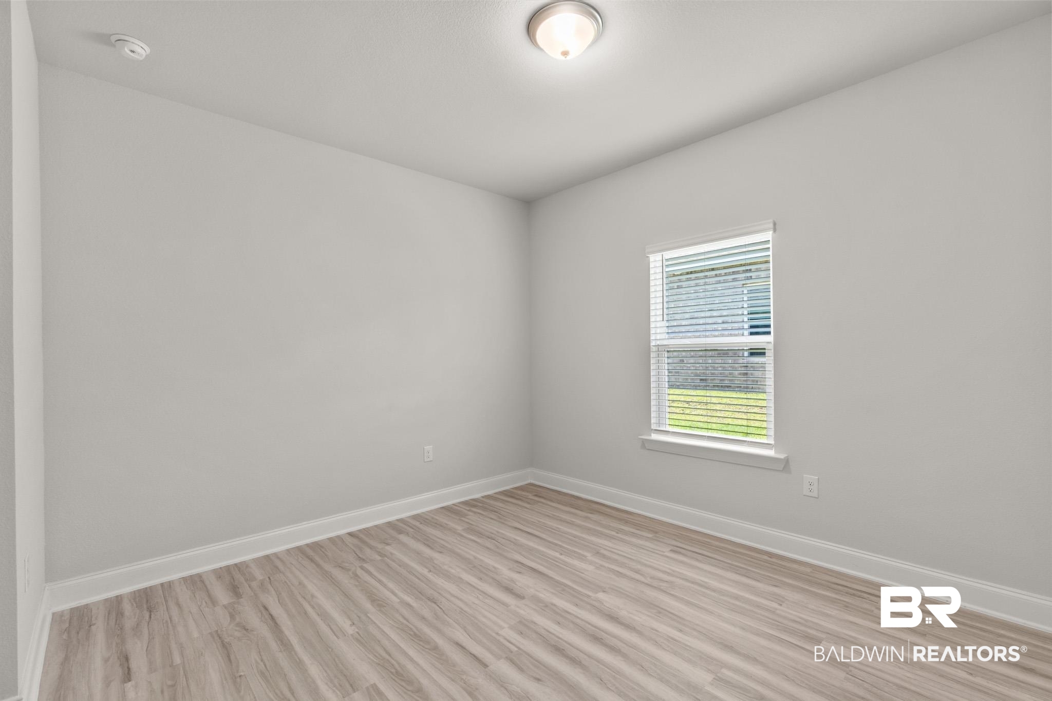 32125 Lyon Road Daphne, AL 36527 - Photo 20 of 70 Room with light gray walls, white trim, and wood-finish flooring