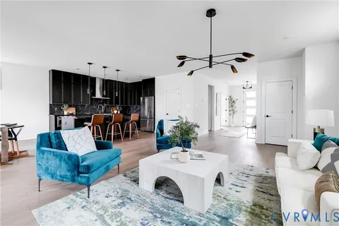 a living room with furniture a large window and kitchen view