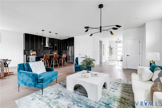a living room with furniture a large window and kitchen view
