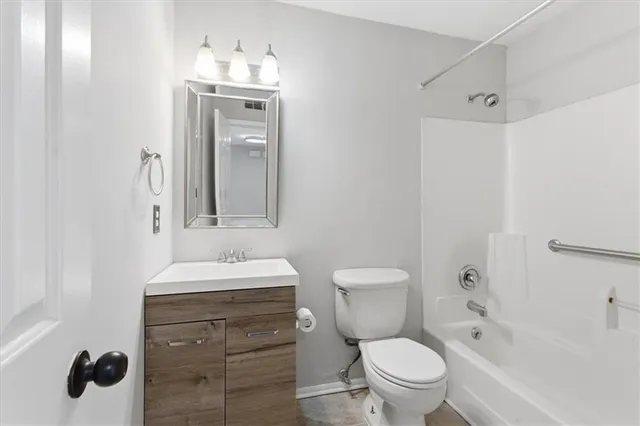 a bathroom with a toilet sink a mirror a vanity and shower